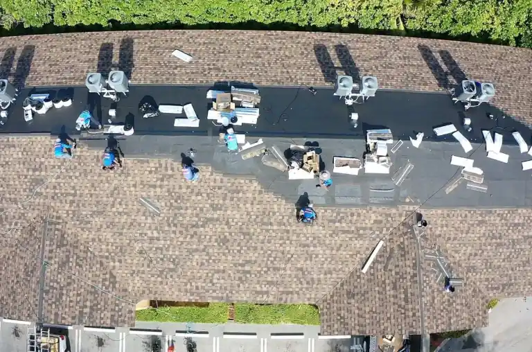 Overhead view of workers installing a flat roof section on a residential building in Lake Worth Beach