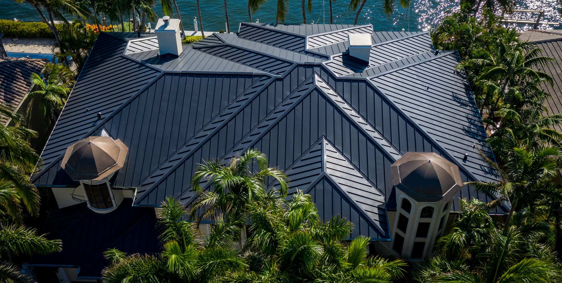 Dark metal roof waterfront estate with cupolas