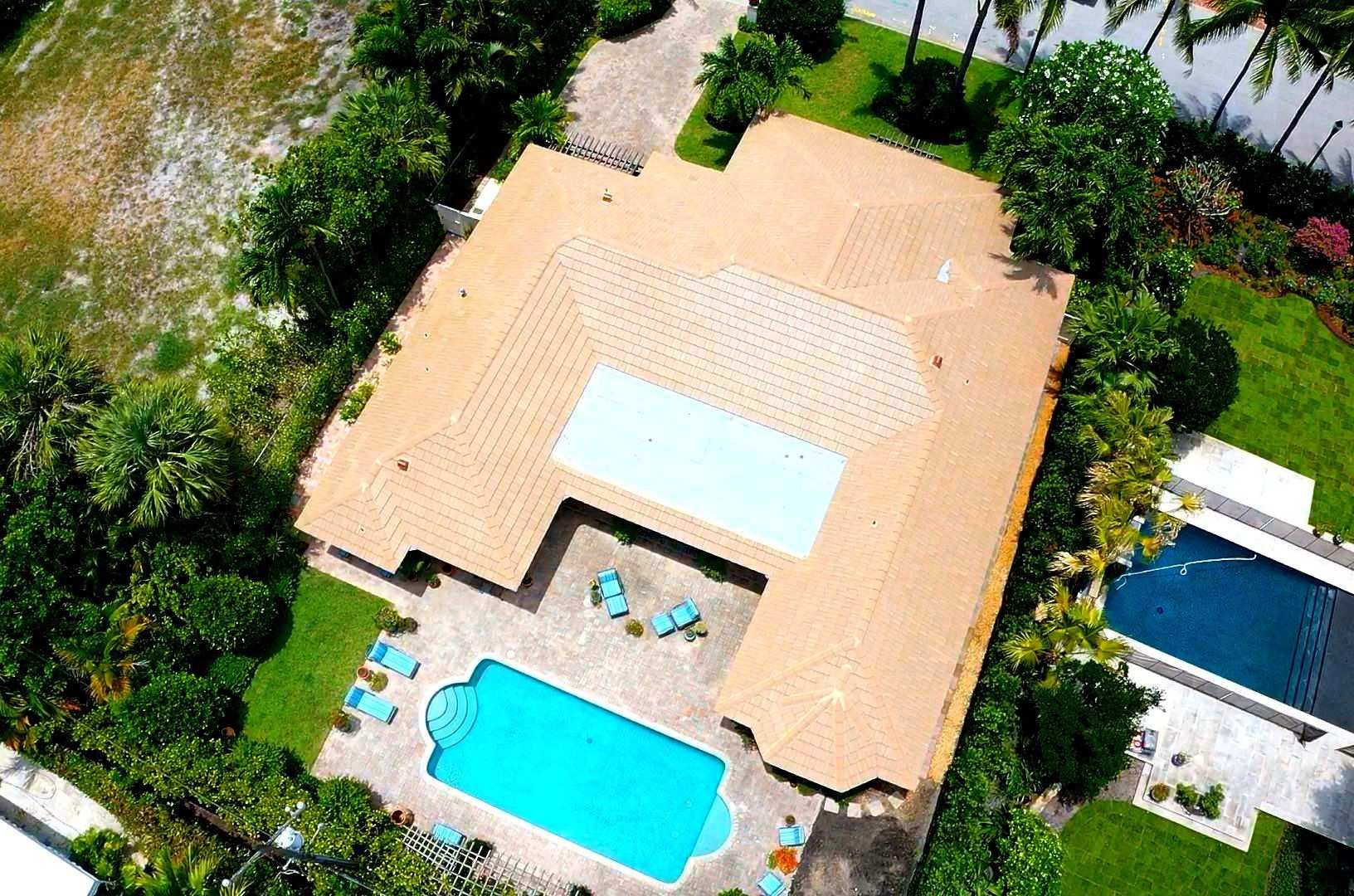 Tan flat tile roof estate with pool