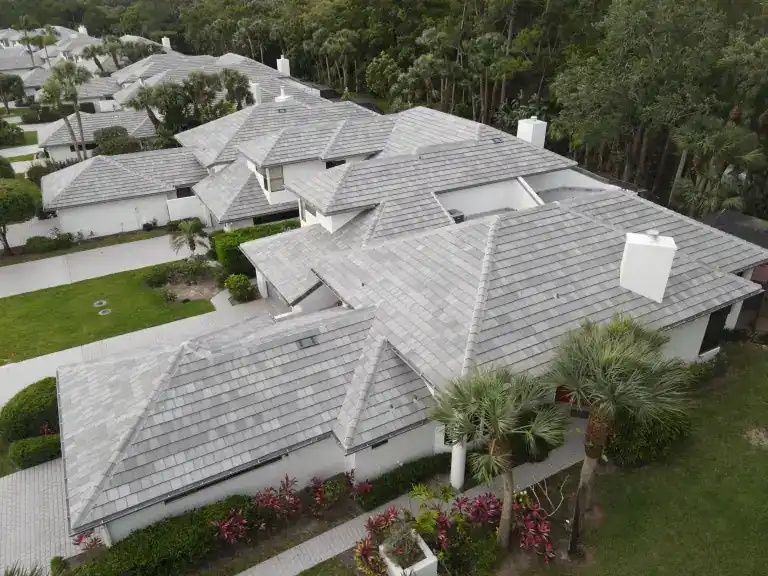 Gray tile roof on a single-story home with lawn and palms in West Palm Beach, photographed April 2024